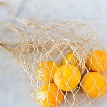 Jute string bag with oranges inside