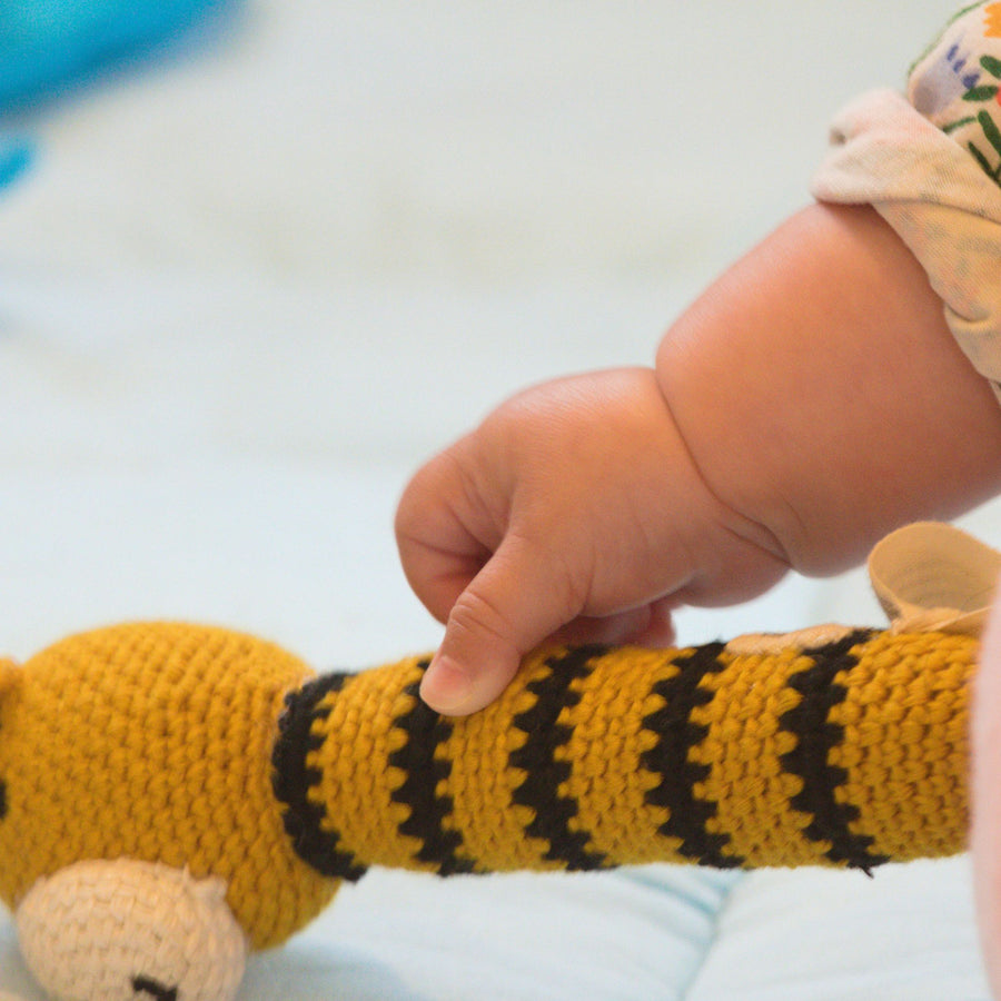 Baby holding fair trade crochet rattle
