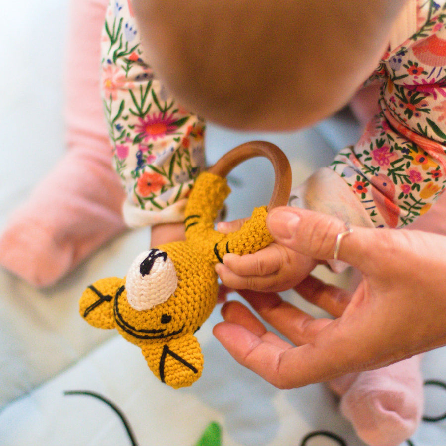 Baby playing with crochet play ring tiger