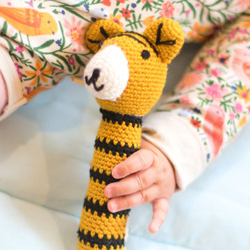 Baby holding fair trade crochet rattle
